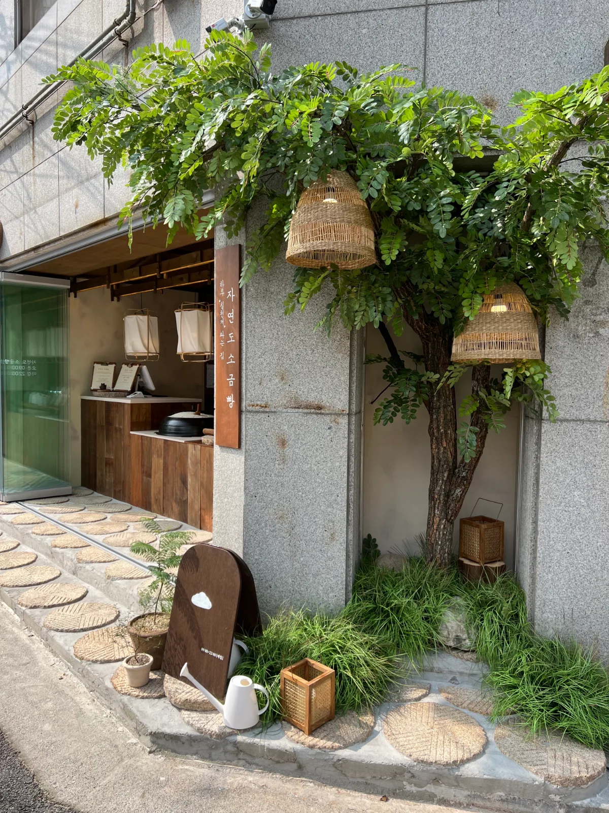 ジャヨンド塩パン 聖水店 — 緑と籠灯りに囲まれた店先