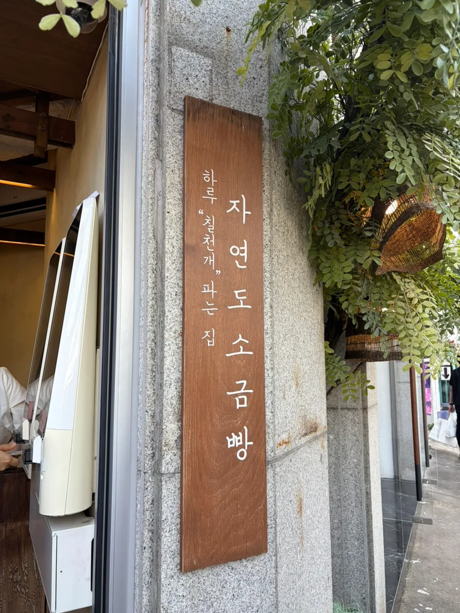 ジャヨンド塩パン 聖水店 — 木製看板と店先の緑