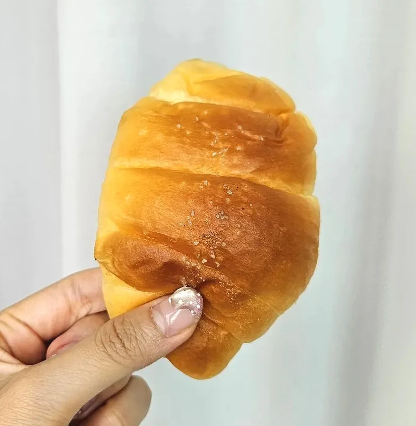 手に持った塩粒付きパン