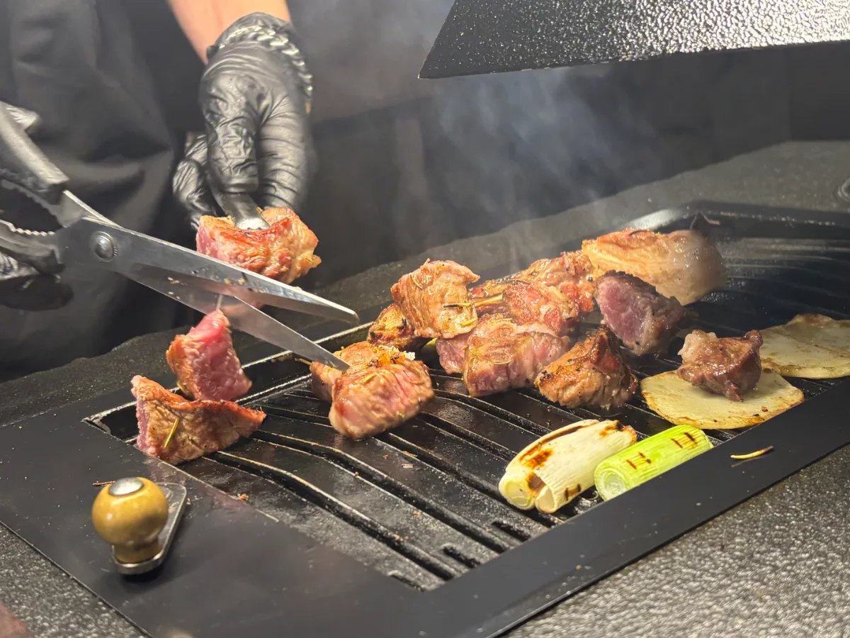 鉄板で肉を切り分ける手元