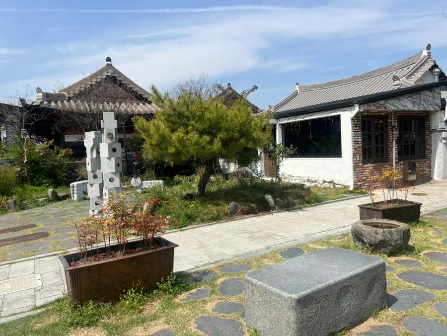 松と石造作品のある韓屋庭園