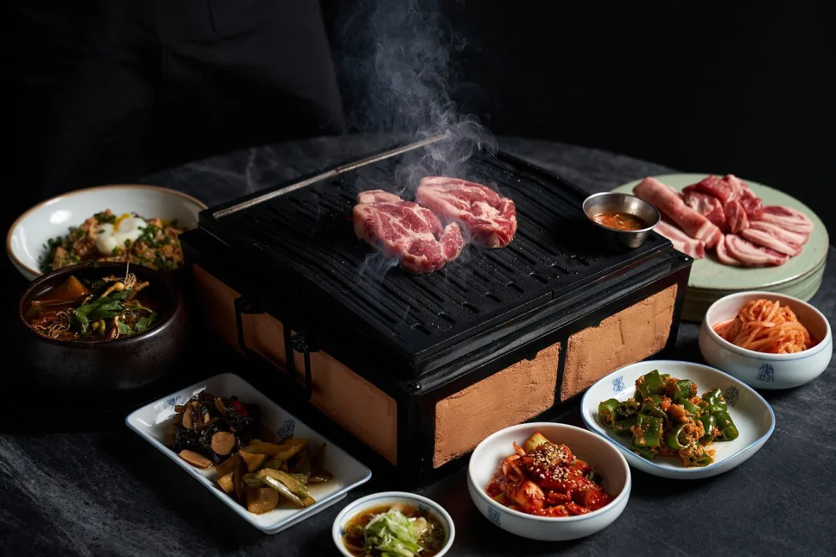 直火匠人 新堂本店 — 焼き肉と小皿料理が並ぶ食卓