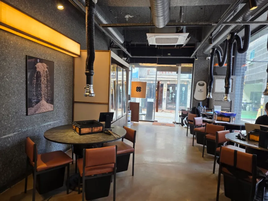 直火匠人 新堂本店 — 丸テーブルと焼肉用の排煙ダクト