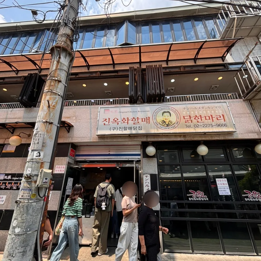 電柱前に人が並ぶ店先