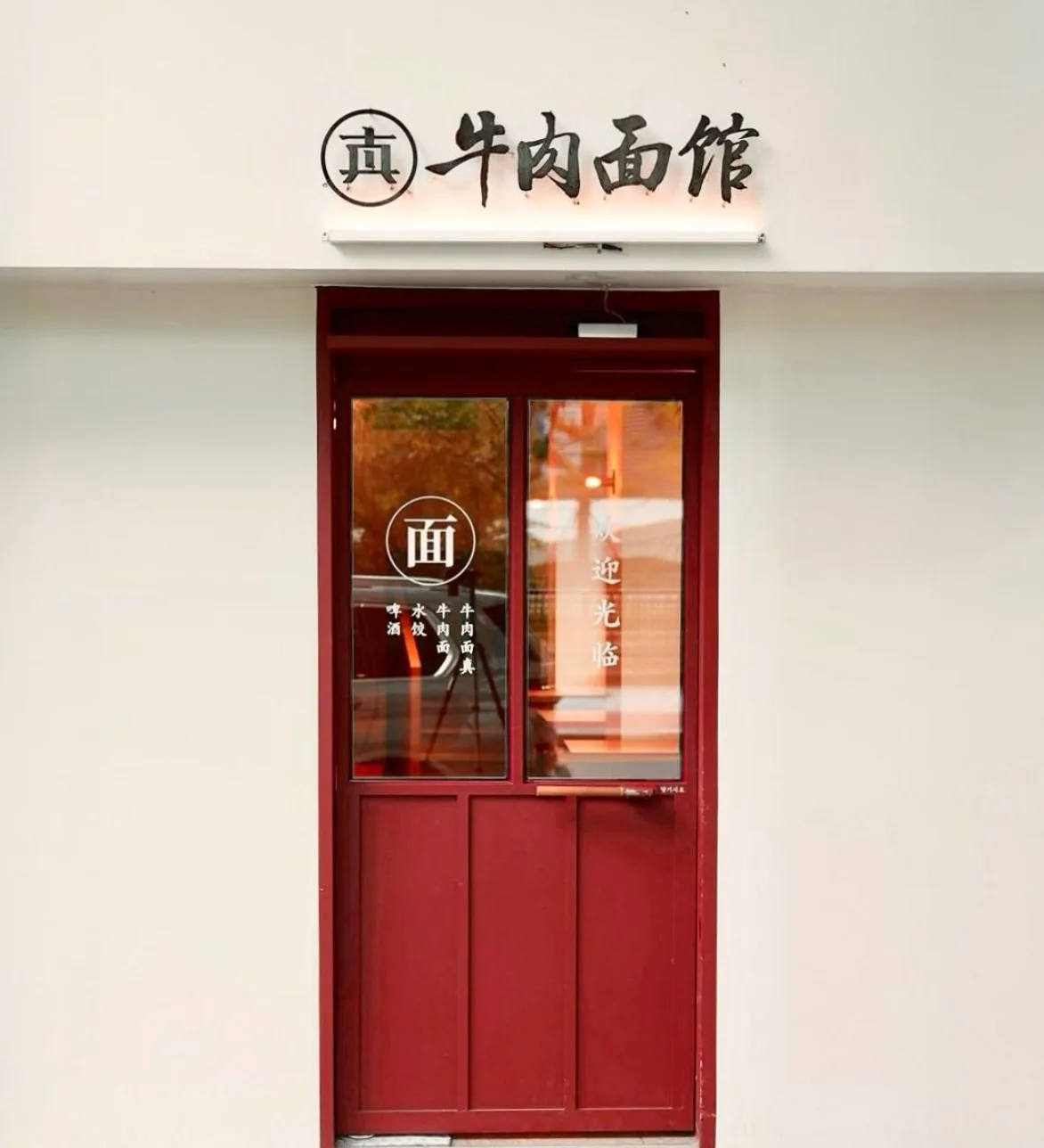 ジンジュン牛肉麺館 本店 — 牛肉面館の看板と赤い扉