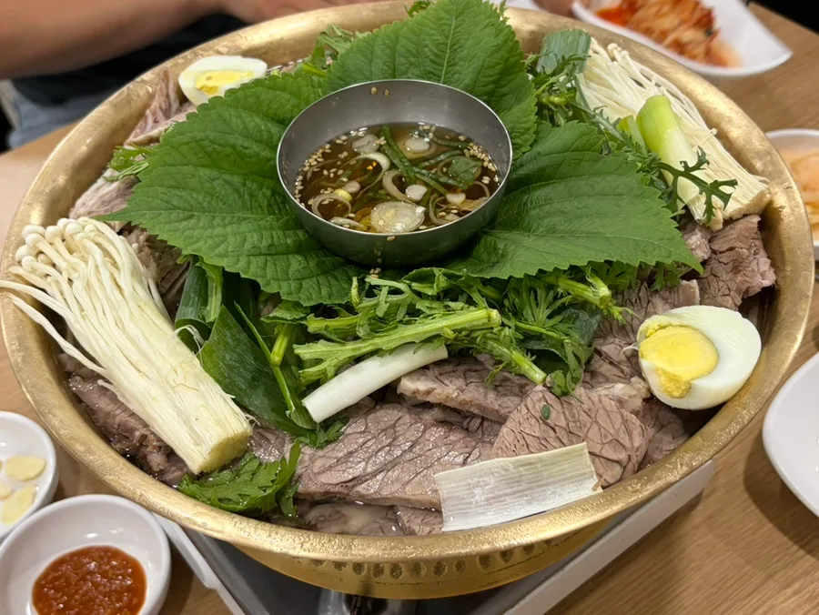 真味平壌冷麺 — 牛肉と青菜を盛った真鍮鍋