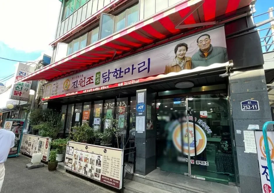 人物写真入りの看板を掲げた店先