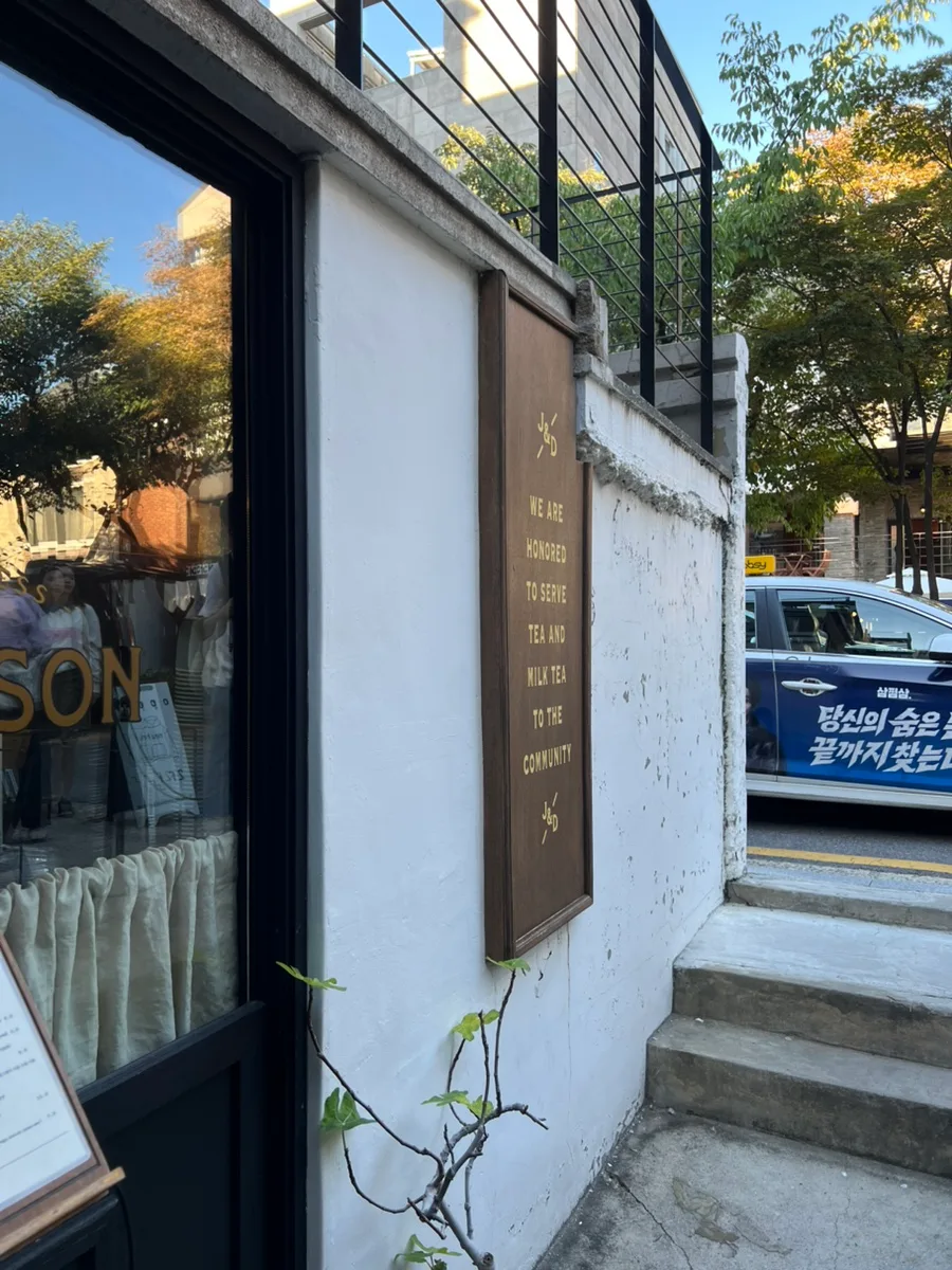 白壁と木製看板の店先