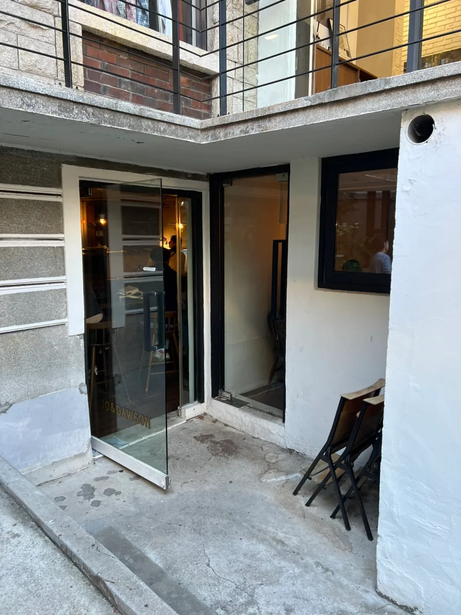 JO & DAWSON 延南本店 — 白壁に囲まれた半地下の入口