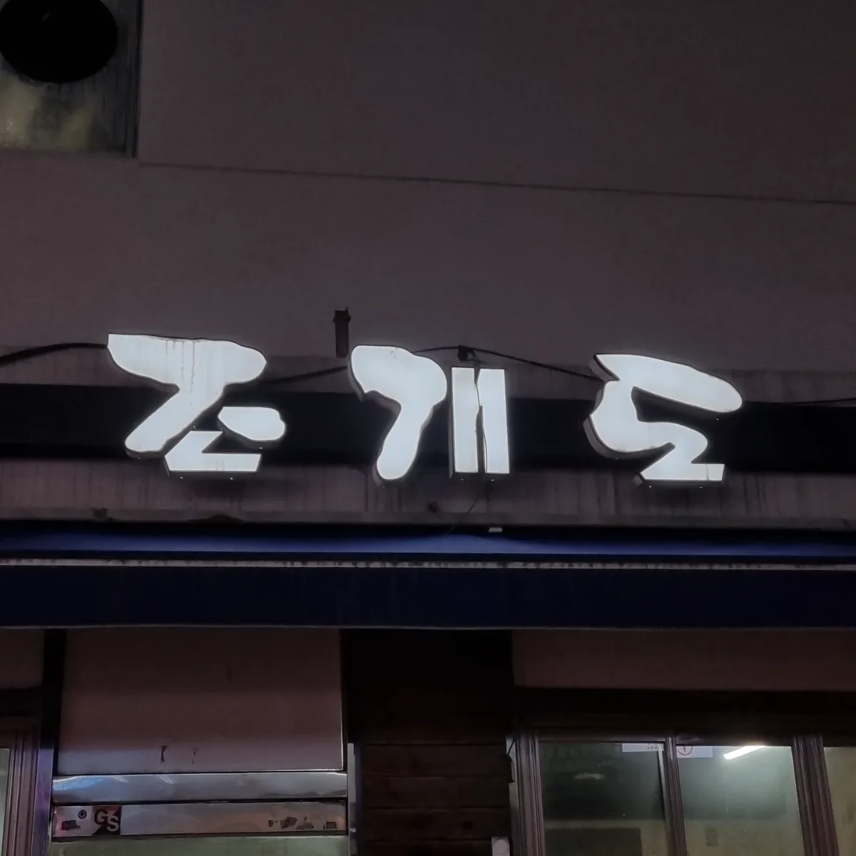 夜に浮かぶ看板の白い文字