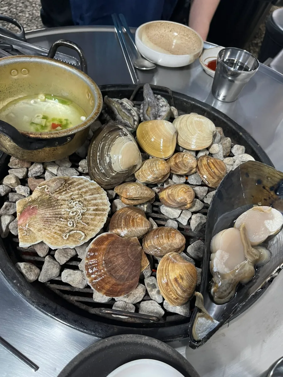 アワビやホタテが並ぶ石焼き網