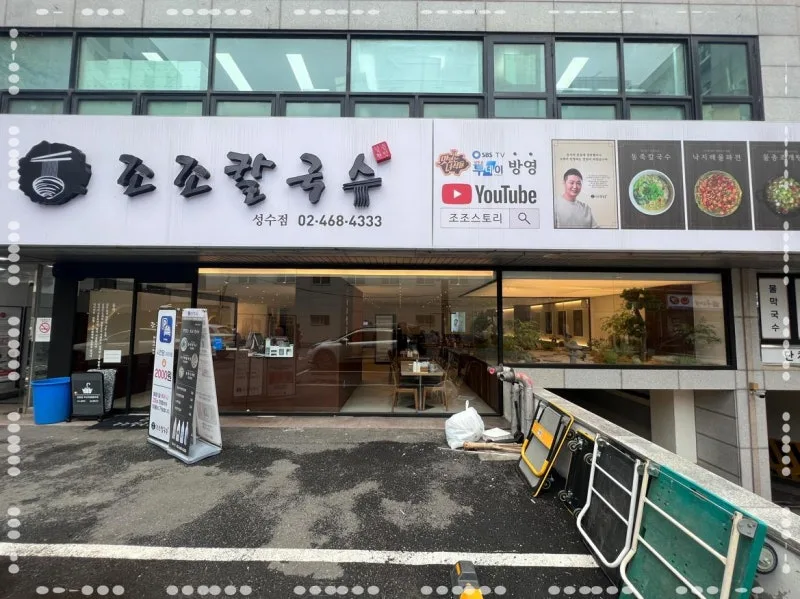 白い外壁の店舗看板とYouTube案内
