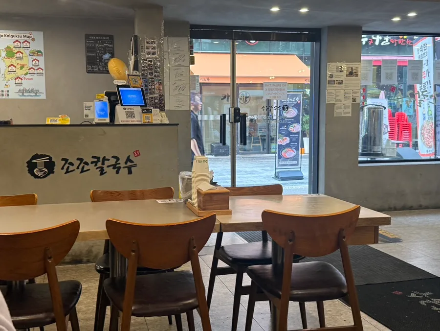 木製テーブルと窓外の通りが見える店内