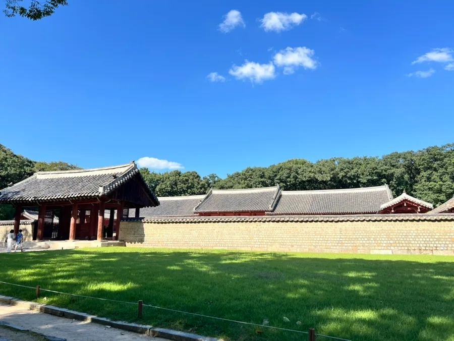 芝生越しに望む門と瓦塀