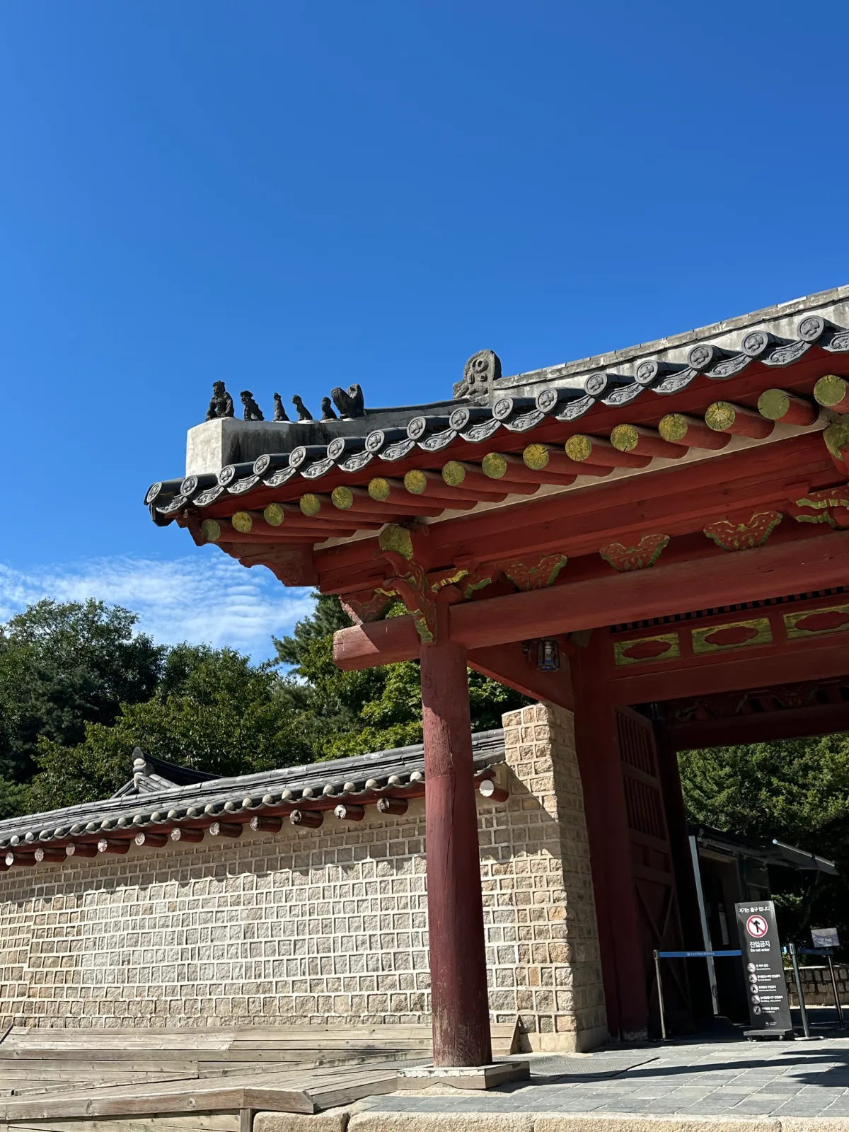 朱塗りの門を飾る瓦と彩色