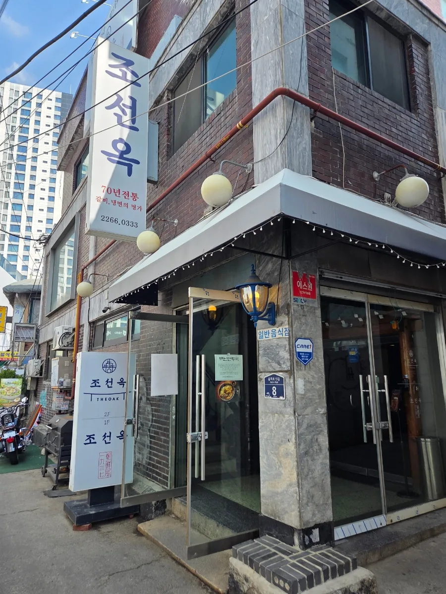 朝鮮屋 — 縦長の看板が掛かる角の店構え