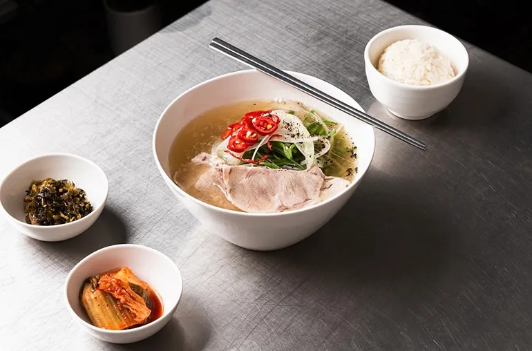豚肉をのせた澄んだスープ麺と付け合わせ