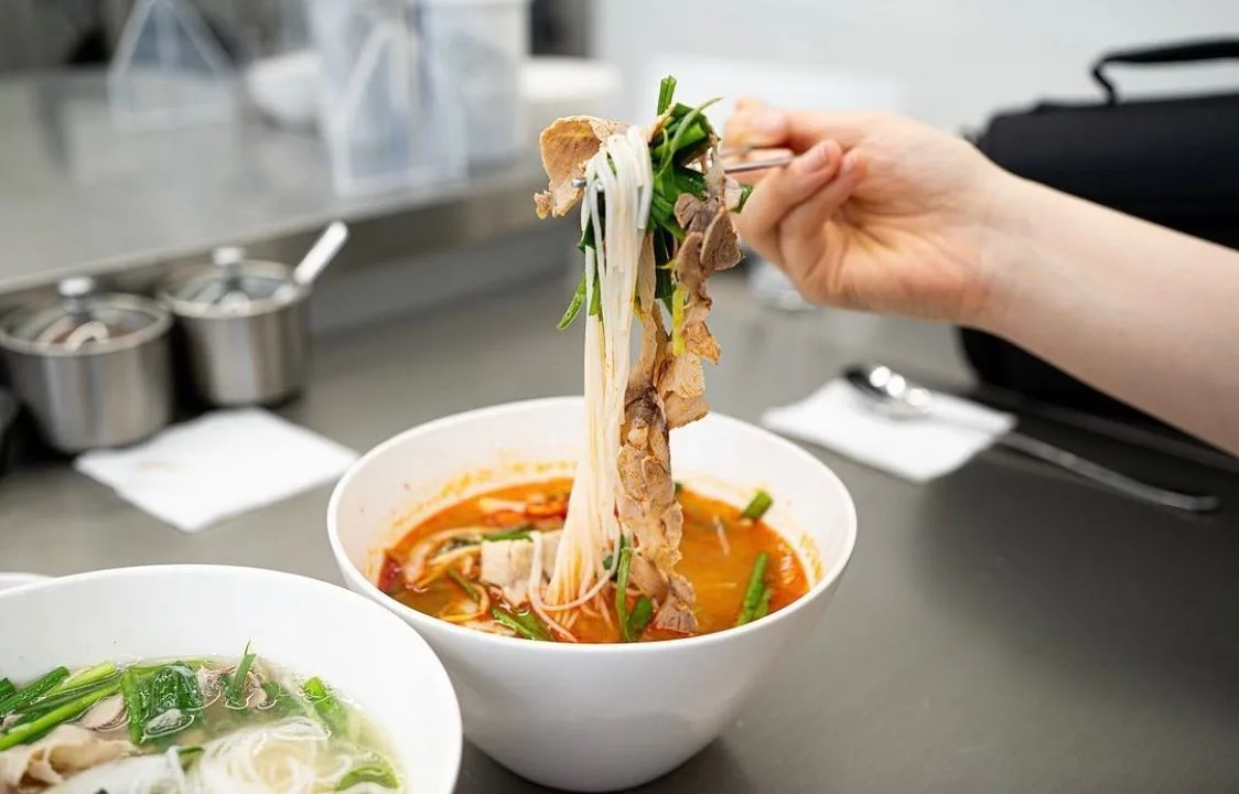 情麺 — 箸で持ち上げた赤い米麺