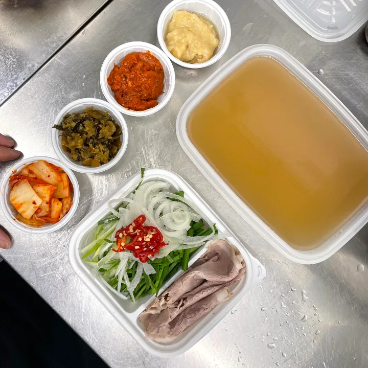 容器に分けられた持ち帰り用のスープと麺、具材