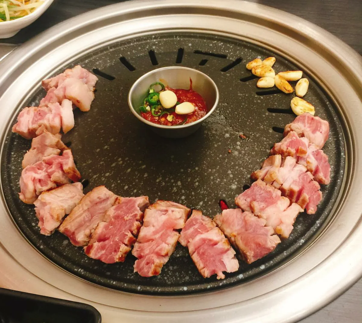 円形の鉄板に並ぶ厚切りの豚肉