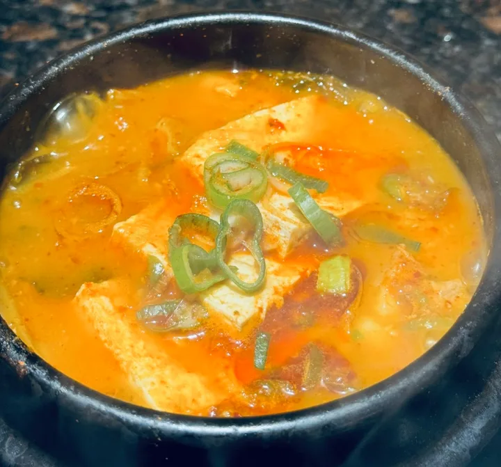 赤いスープの土鍋と豆腐ネギ