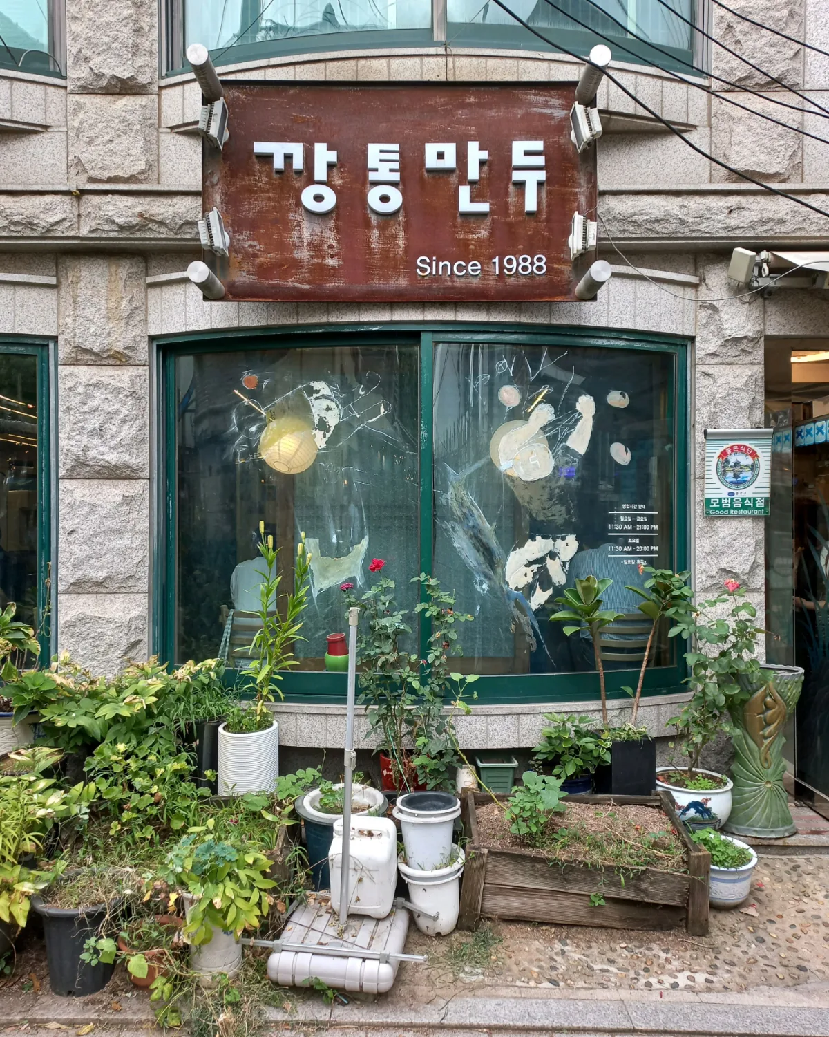 植木に囲まれた店の正面