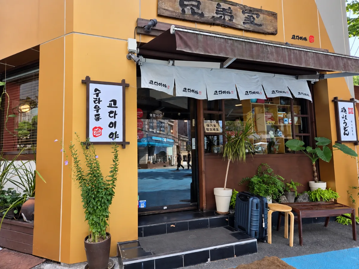 暖簾と植木が並ぶ教大二雅