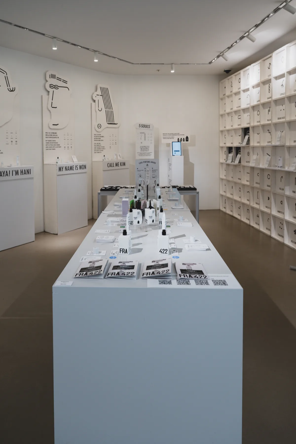 白い展示台が伸びる香水店