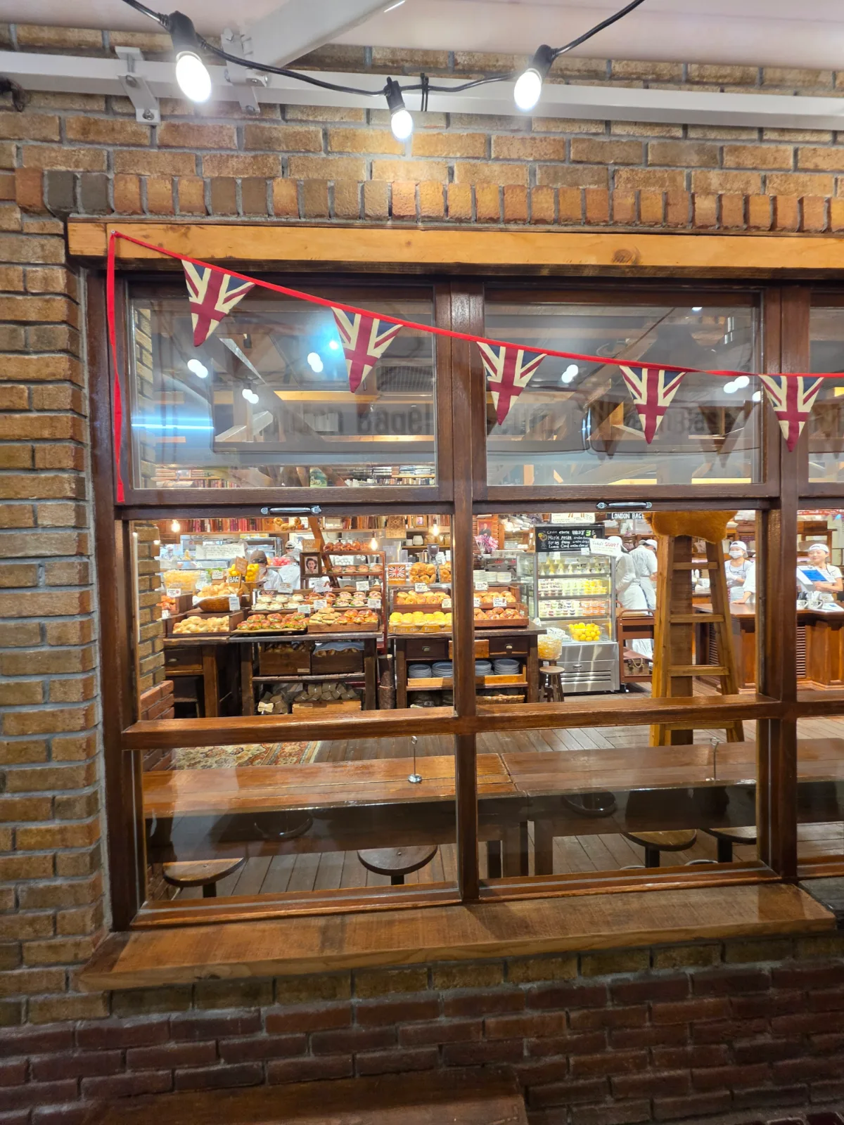 ロンドンベーグルミュージアム 西面店 — 英国旗の飾りが並ぶ店の窓辺