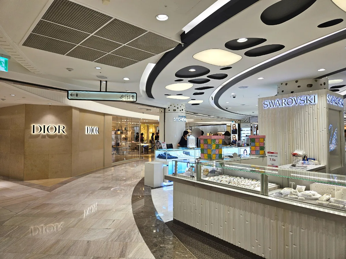 ロッテ免税店 明洞本店 — 曲線天井と宝飾カウンター