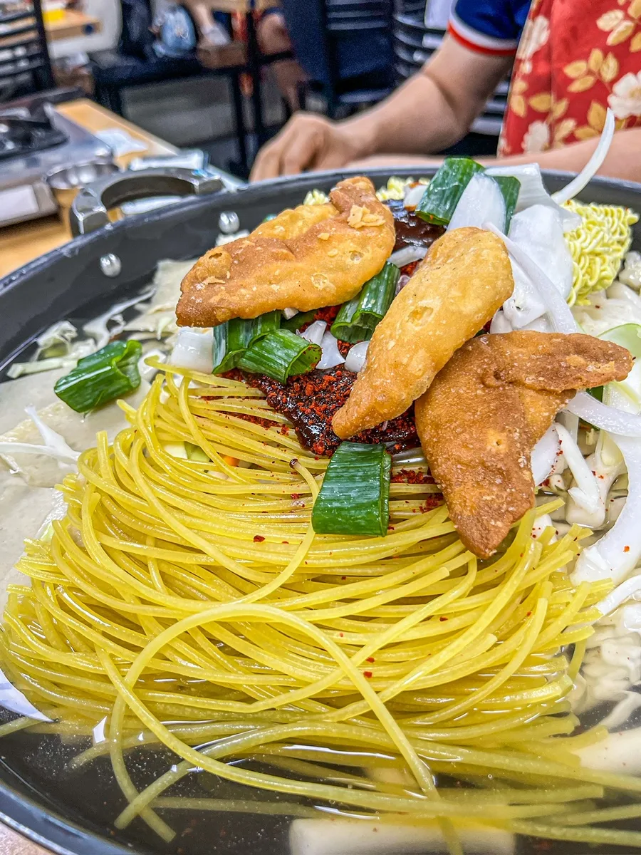 マ・ボンリム ハルモニチッ — 麺と揚げ餃子を載せた鍋