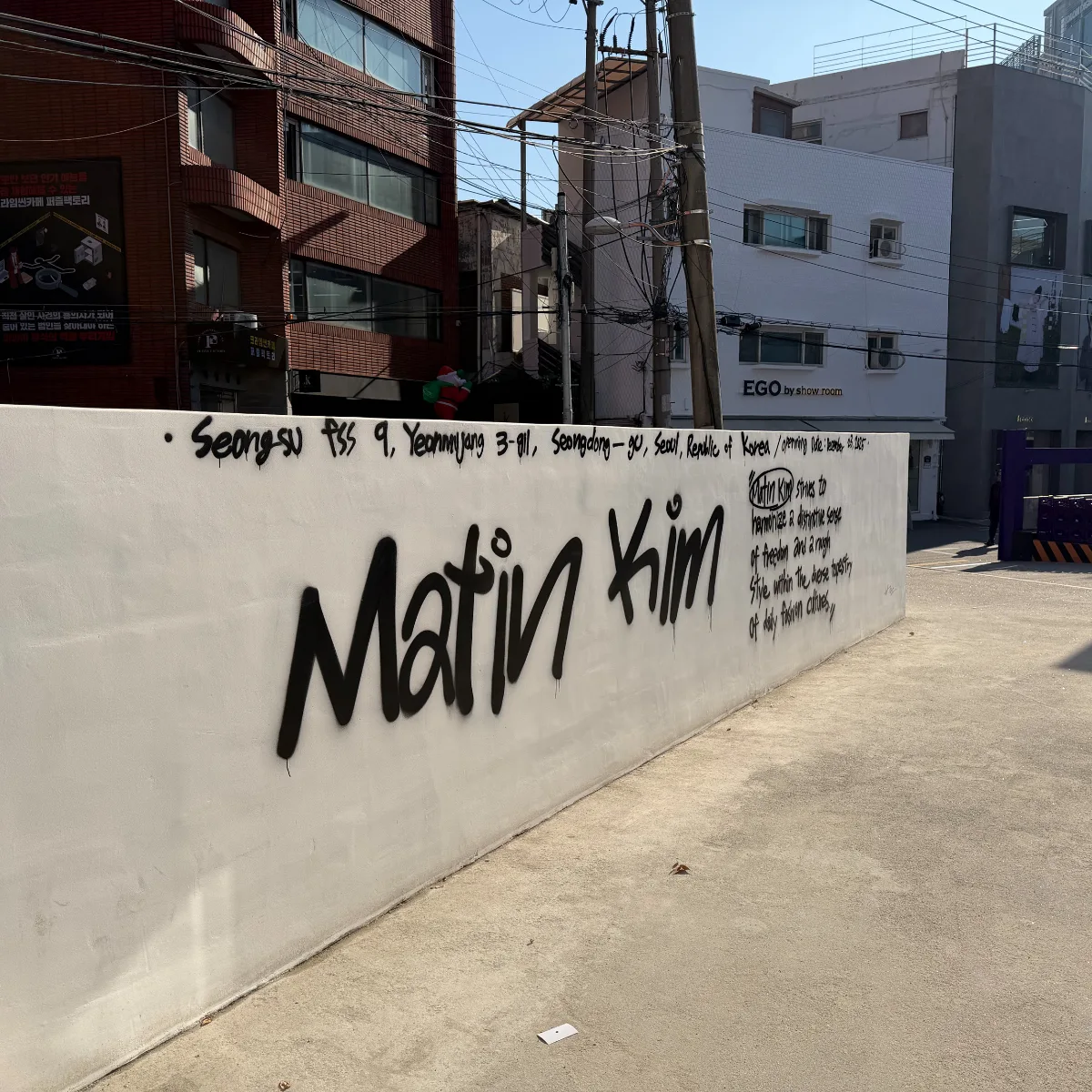 ロゴを描いた白い路地壁