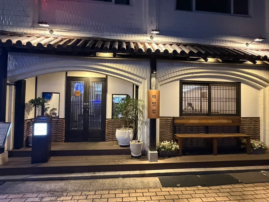 夜灯りに浮かぶ瓦ひさしの店先