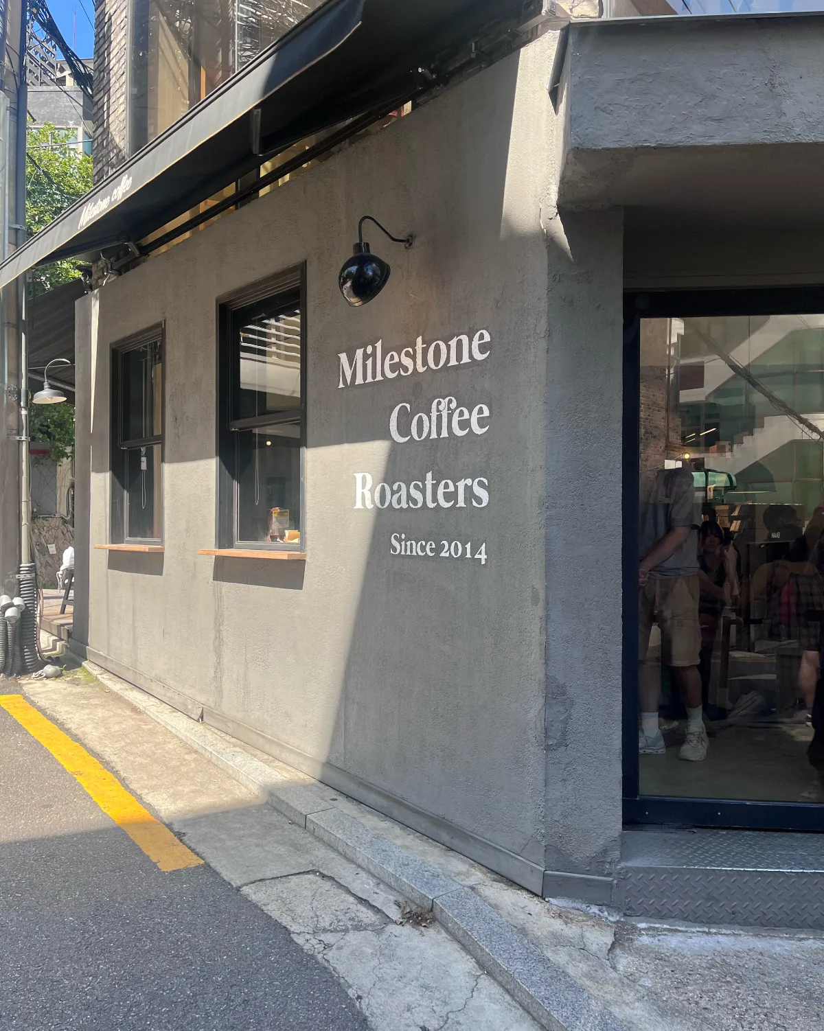 MILESTONE COFFEE 漢南店 — 店名が描かれた灰色の外壁