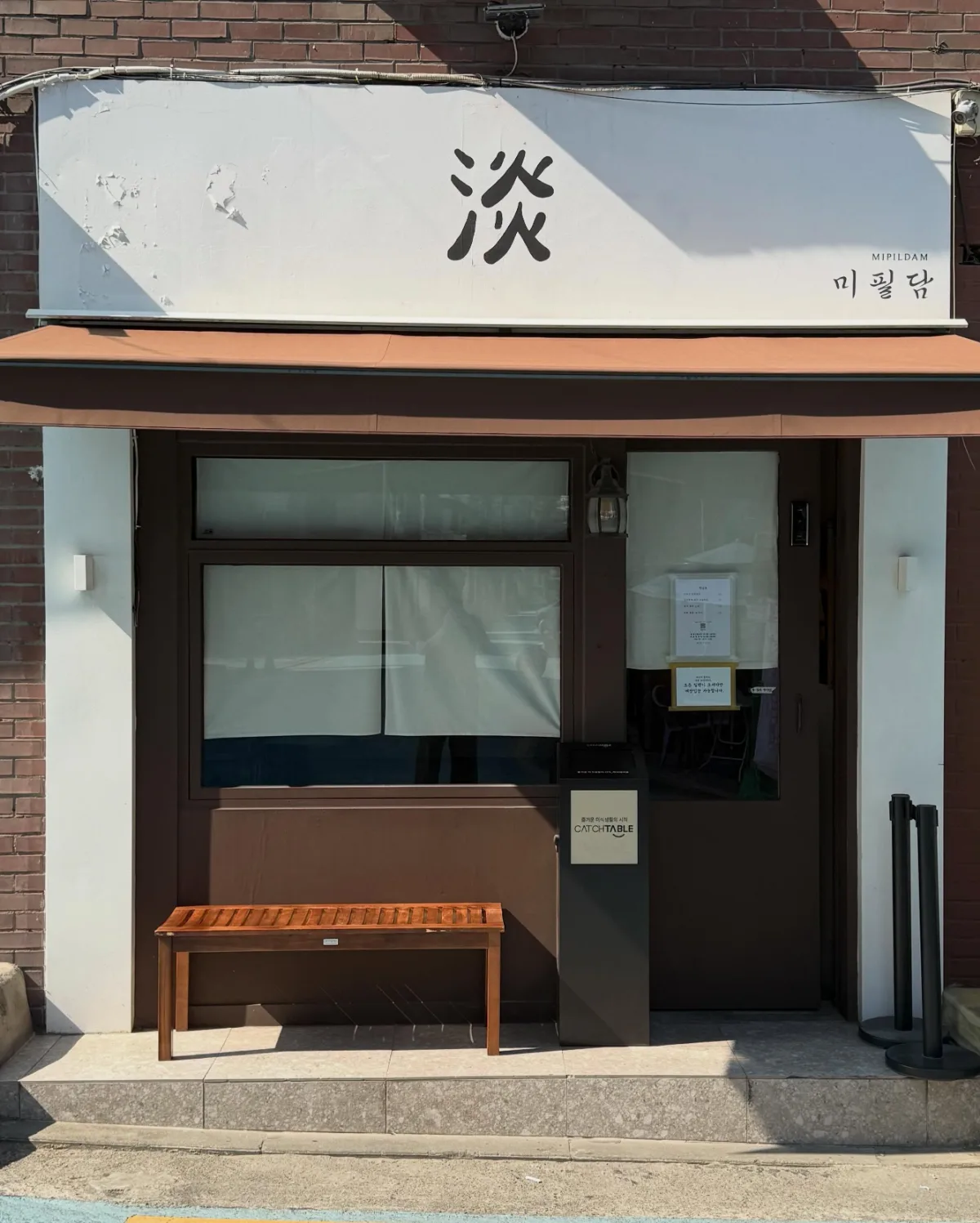 Mipildam — 「미필담」の看板と茶色のひさし