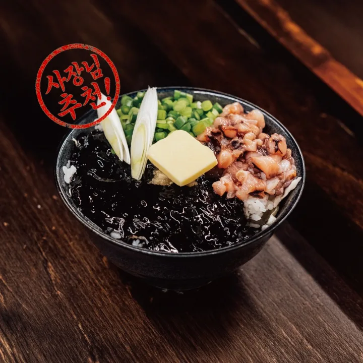 イカ墨の黒いソースがかかった丼