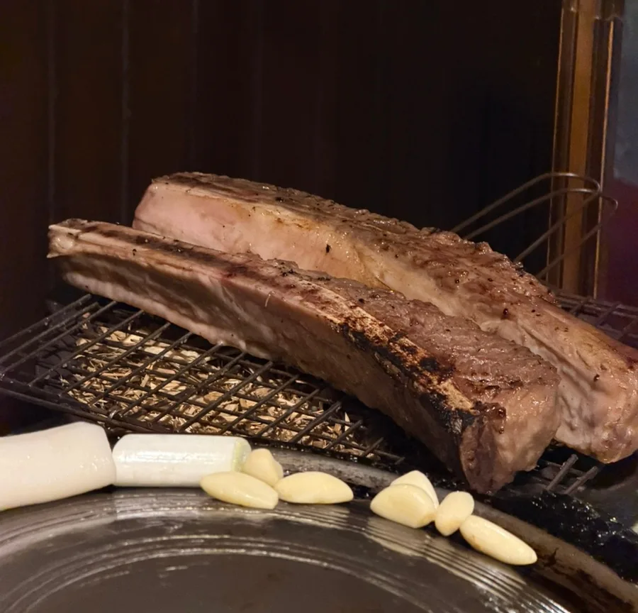 藁の上で焼く骨付き肉とニンニク