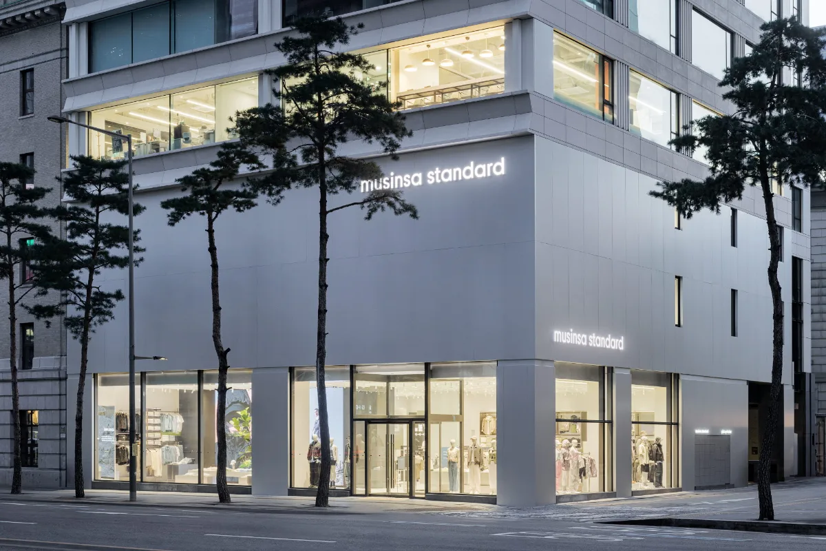 MUSINSA STANDARD 明洞店 — 松並木に面した白い店舗