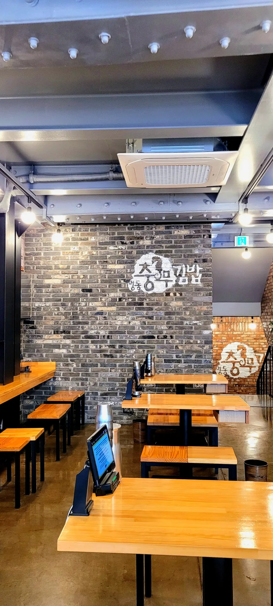 忠武キンパ 明洞1号店 — 店名ロゴと木製テーブル