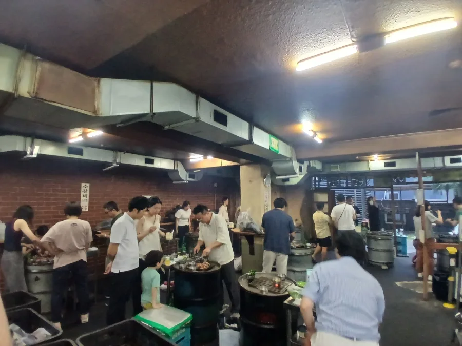 明洞ソソカルビ — ドラム缶を囲んで立つ店内