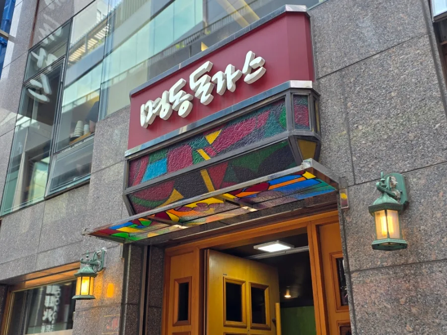 赤い店名看板と木の扉