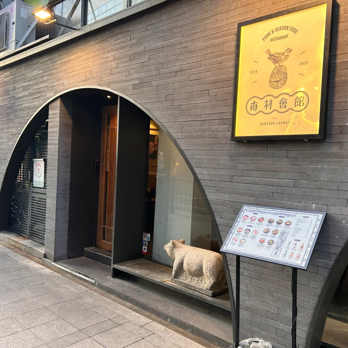 南村会館 市庁本店 — アーチ形の入口と石の豚