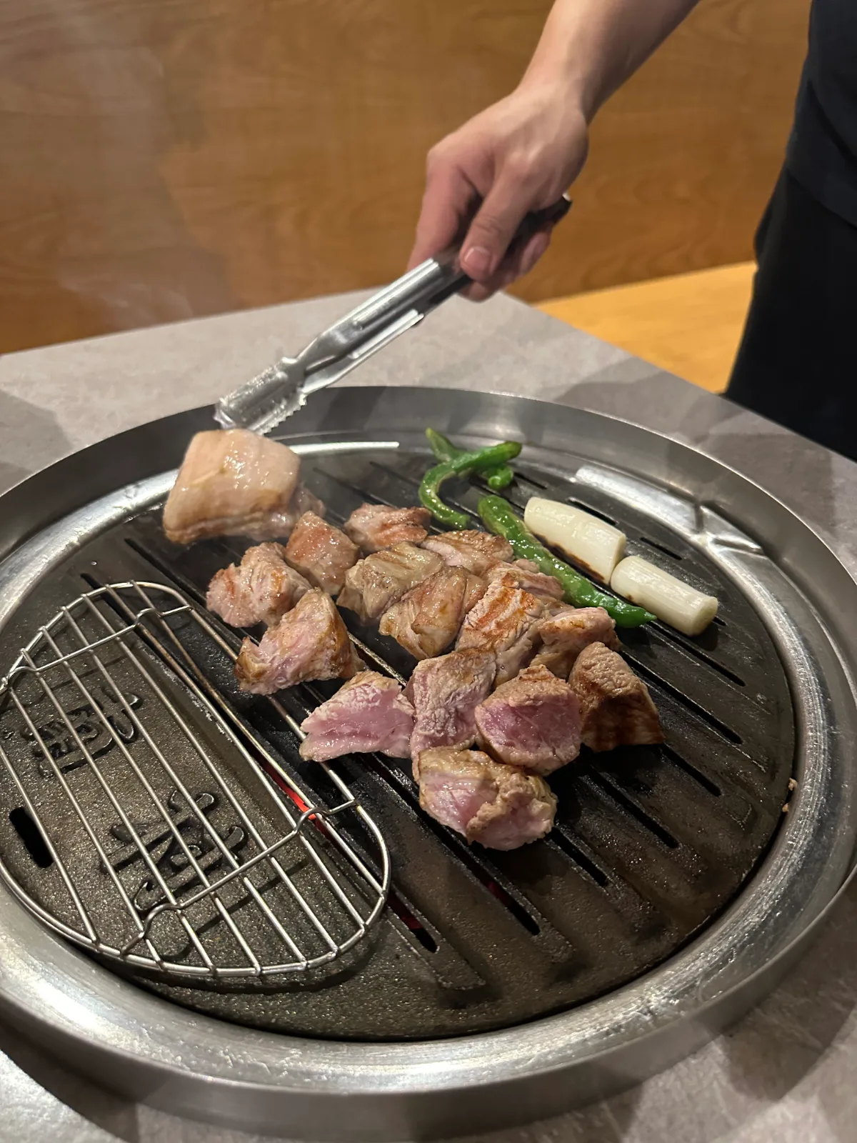 網の上で焼かれる角切りの豚肉
