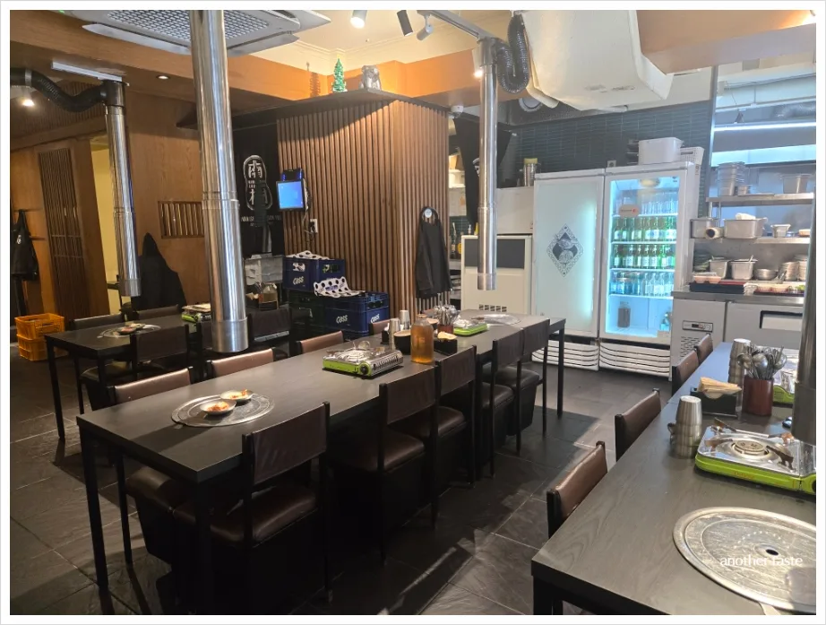 南村会館 市庁本店 — 黒いテーブルが並ぶ店内