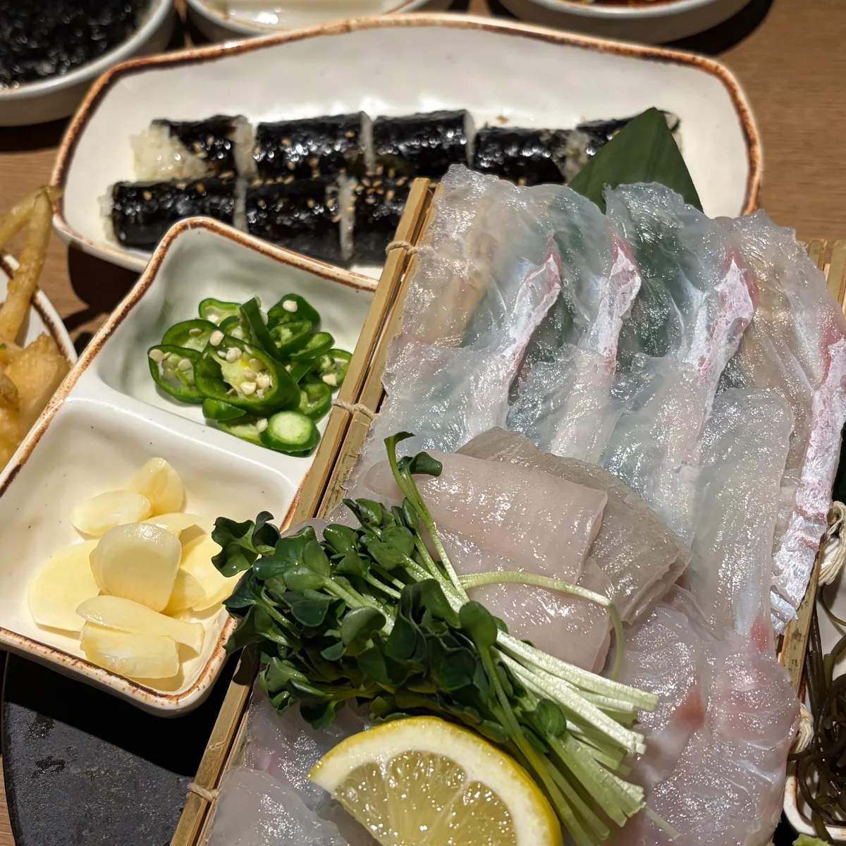 竹ざるの熟成ヒラメと奥に置かれた塩キンパ