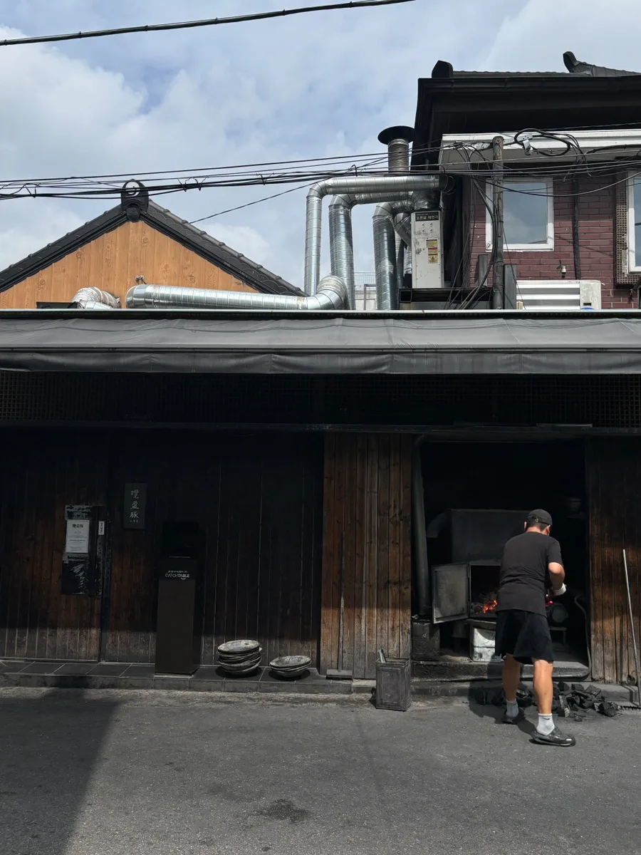 店先で炭火をおこす木造の店舗