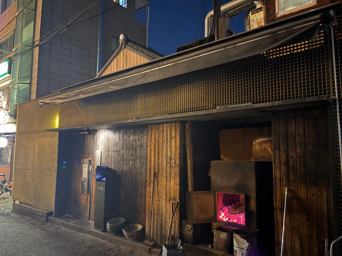 覧盈豚 本店 — 夜に赤く燃える炭火の炉