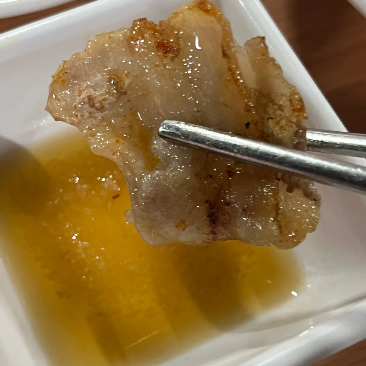 箸でつまんだ焼き豚バラ肉