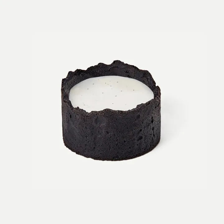 白いクリームを囲む黒い円形ケーキ