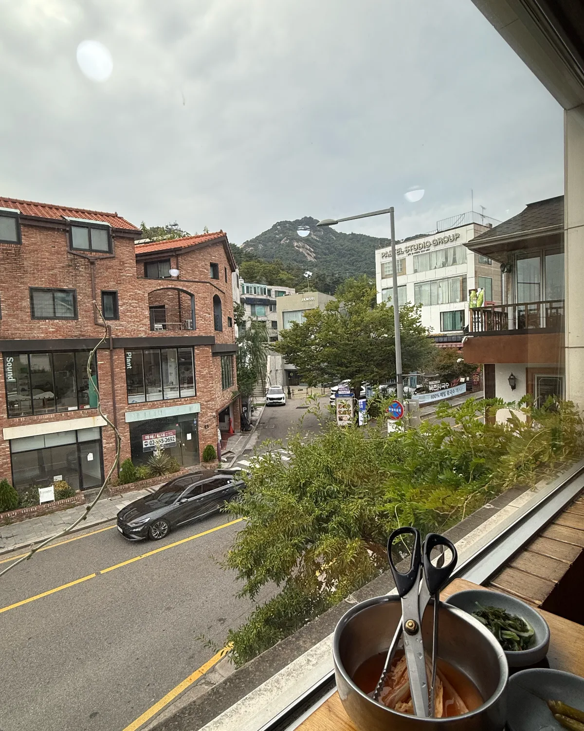 窓越しに望む山と街並み